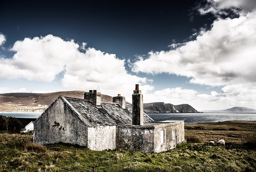 Abandoned stone cottage ruins by the sea in Ireland