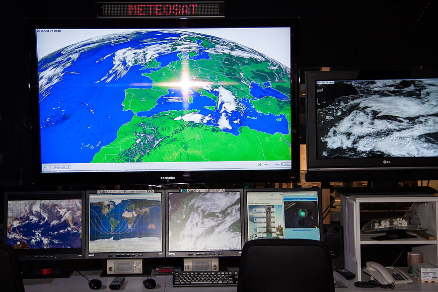 Meteorologist workstation with multiple satellite weather monitoring screens