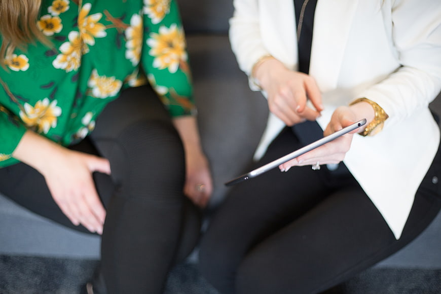Two women discussing business on a tablet
