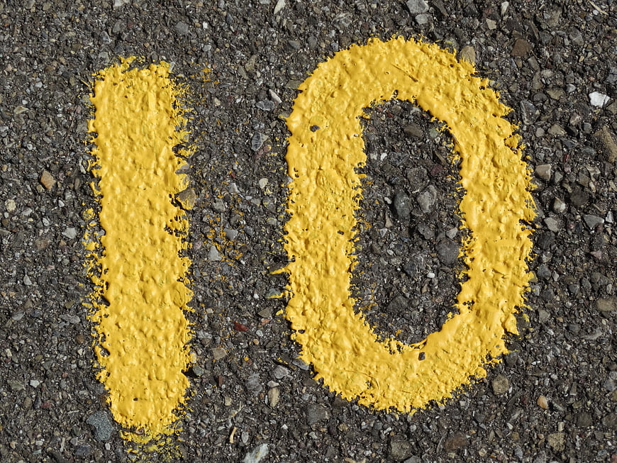 Yellow Number 10 Painted On Rough Asphalt Road Surface