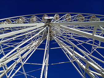 Low angle view of white Ferris wheel against blue sky