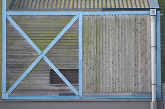 Weathered wooden shed facade with blue painted frame
