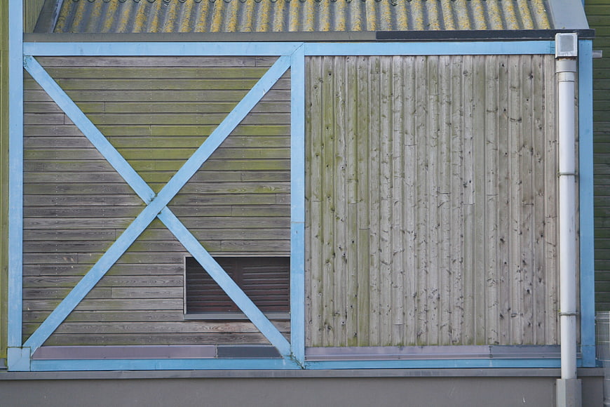 Weathered wooden shed facade with blue painted frame