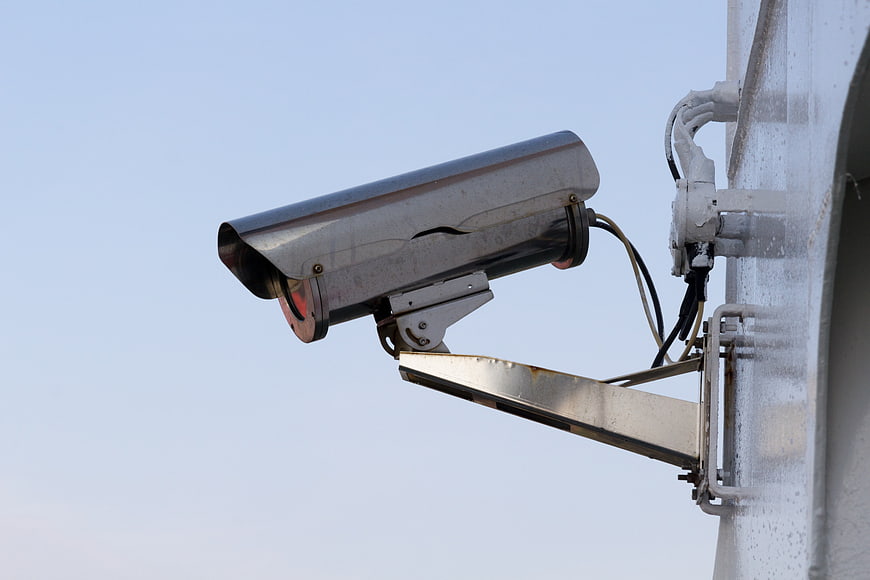 Outdoor Security Camera Mounted on Metal Pole Against Sky