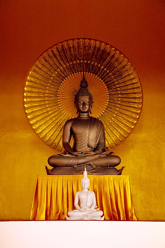 Bronze Buddha statue with golden halo on yellow cloth in temple
