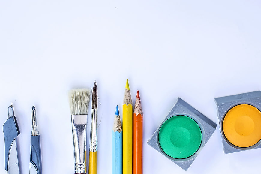 Flat lay of colorful art supplies and drawing tools on white background
