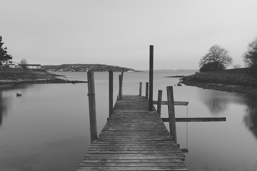 Black and white wooden pier extending into calm water