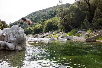 Man Backflipping into River from Rock