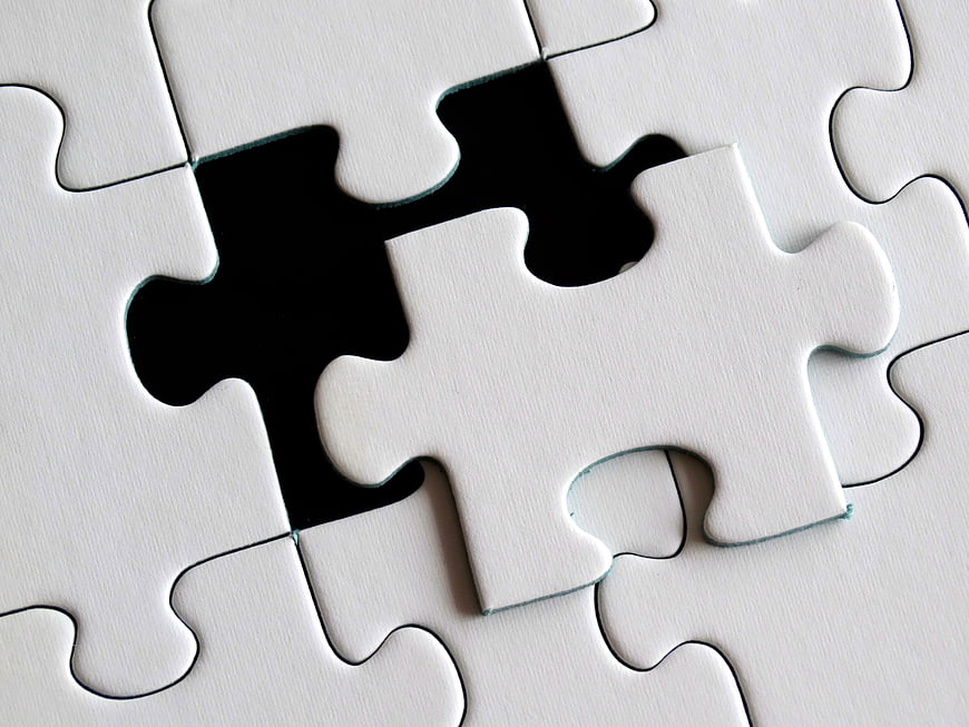 White jigsaw puzzle with missing piece and black background
