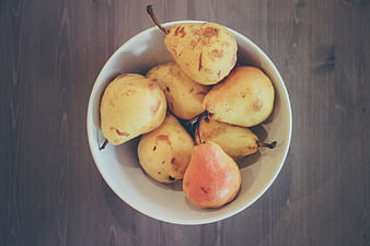 Top View of Fresh Yellow Pears in White Bowl