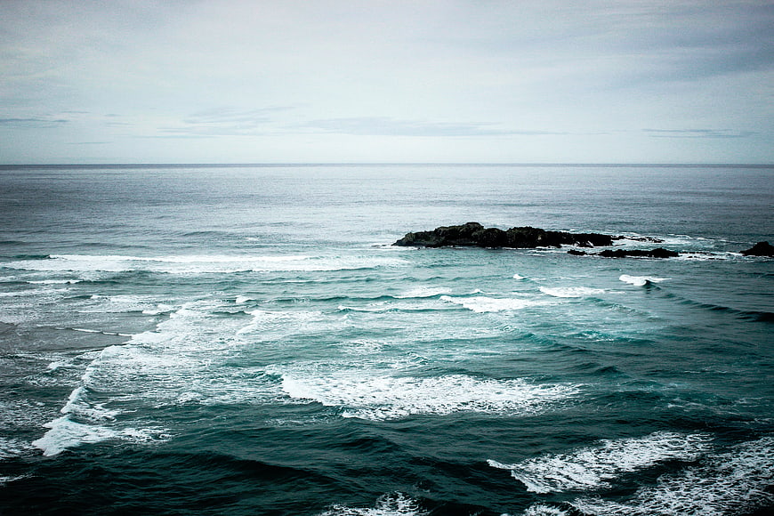 Dramatic ocean waves crashing against dark rocks