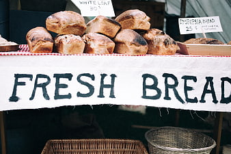 Fresh Bread Market Stall with Handwritten Sign and Wicker Baskets