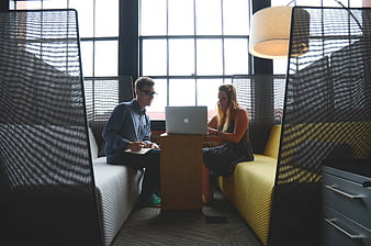 Coworkers collaborating on laptop in modern office