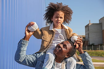 Happy Father Carrying Daughter on Shoulders Outdoors