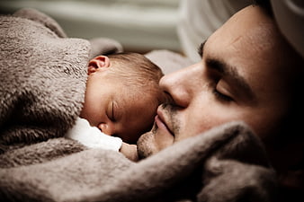 Close-up of Father and Newborn Baby Sleeping Together