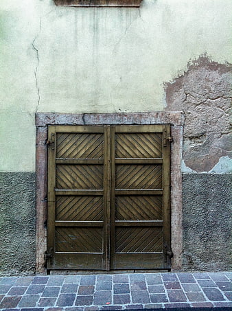Rustic wooden shutters on weathered Italian wall