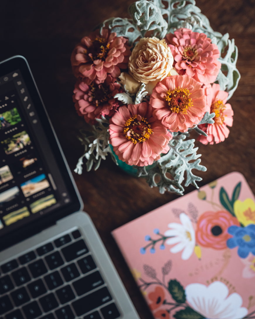 Pink Zinnia Flowers on Wooden Desk with Laptop and Notebook