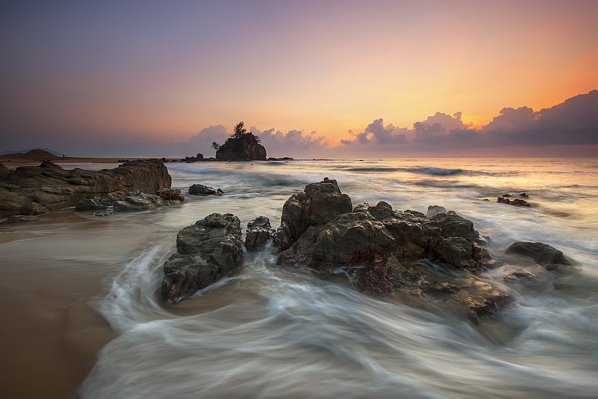 Long Exposure Sunset Seascape with Rocky Shore and Silhouetted Island