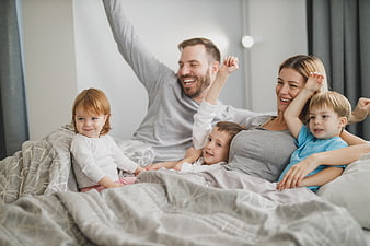 Happy family stretching and waking up together in bed
