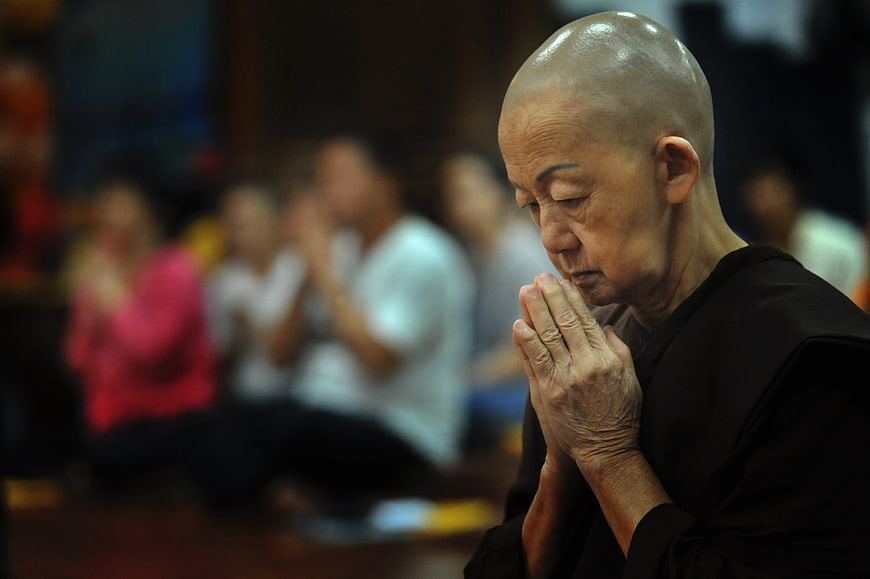 Senior Buddhist Nun Praying in Meditation Hall