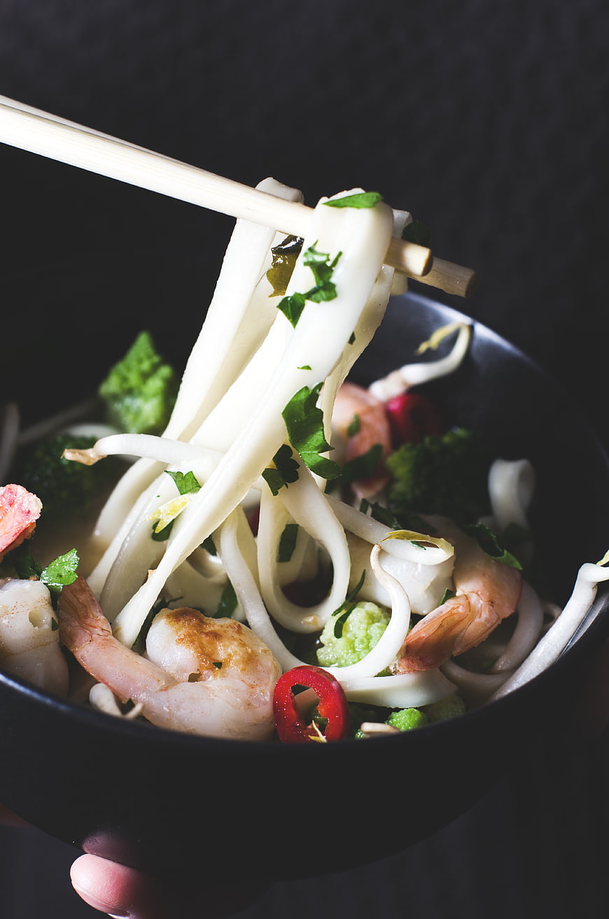 Close-up of shrimp udon noodles with chopsticks