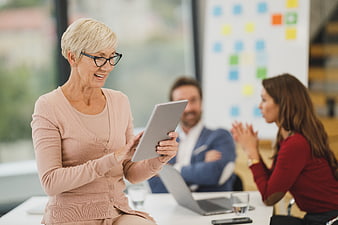 Senior businesswoman using tablet in office meeting