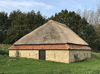 Traditional Thatched Sheepfold in Green Pasture