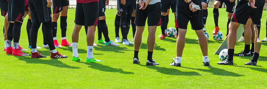 Soccer Team Legs and Cleats on Green Grass Field