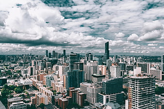 Aerial View of Modern City Skyline Under Dramatic Clouds