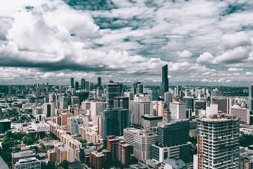 Aerial View of Modern City Skyline Under Dramatic Clouds