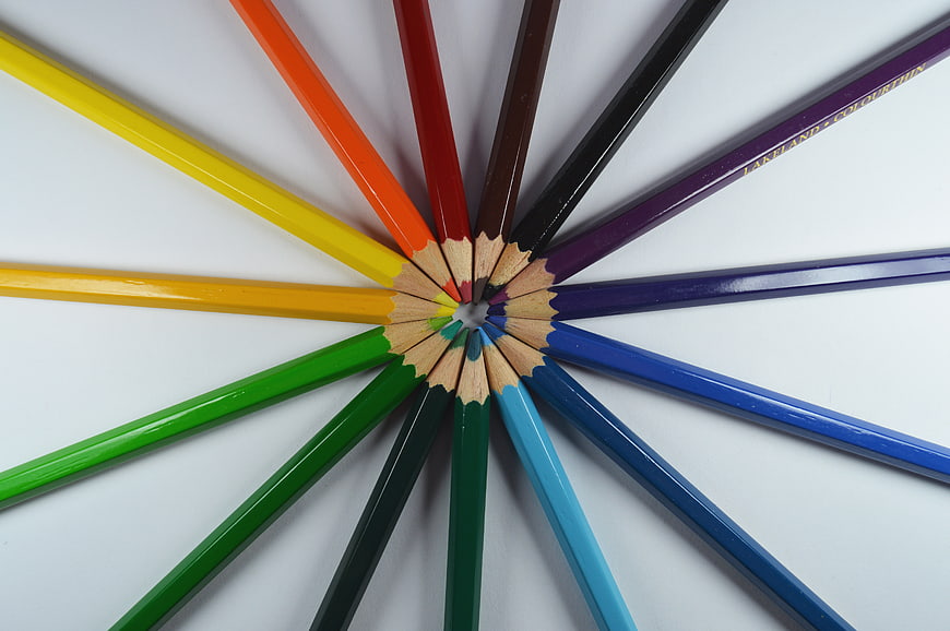 Colorful pencils arranged in a circle on white background