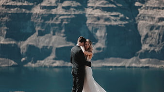 Romantic Wedding Couple Embracing by Lake with Mountains