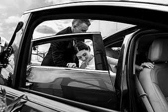 Bride and Groom Entering Wedding Car in Black and White