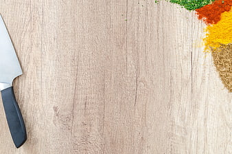 Top View of Chef Knife and Colorful Spices on Wooden Table