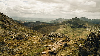 Rugged Mountain Landscape with Rocky Trail and Cloudy Sky