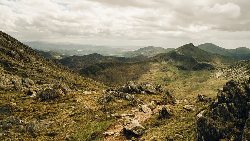 Rugged Mountain Landscape with Rocky Trail and Cloudy Sky