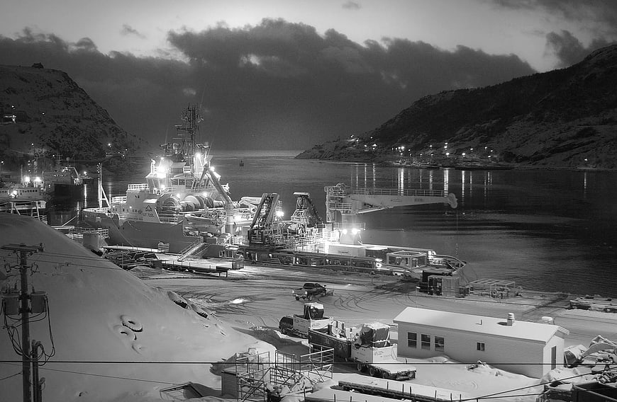 Grayscale Night View of Icebreaker Ship Docked in Snowy Harbor