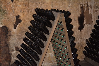 Wine bottles stored in wooden racks in a rustic cellar
