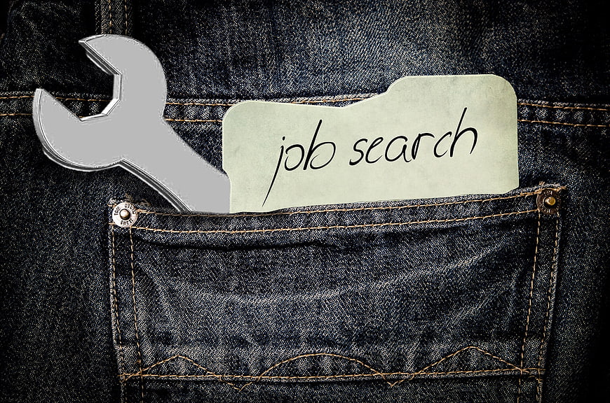 Job search folder and wrench in blue jeans pocket
