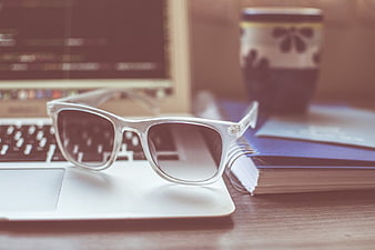 White Sunglasses on Laptop with Coffee and Notebook