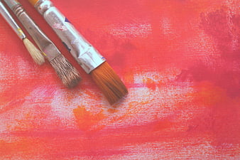 Paintbrushes on Red Canvas Background