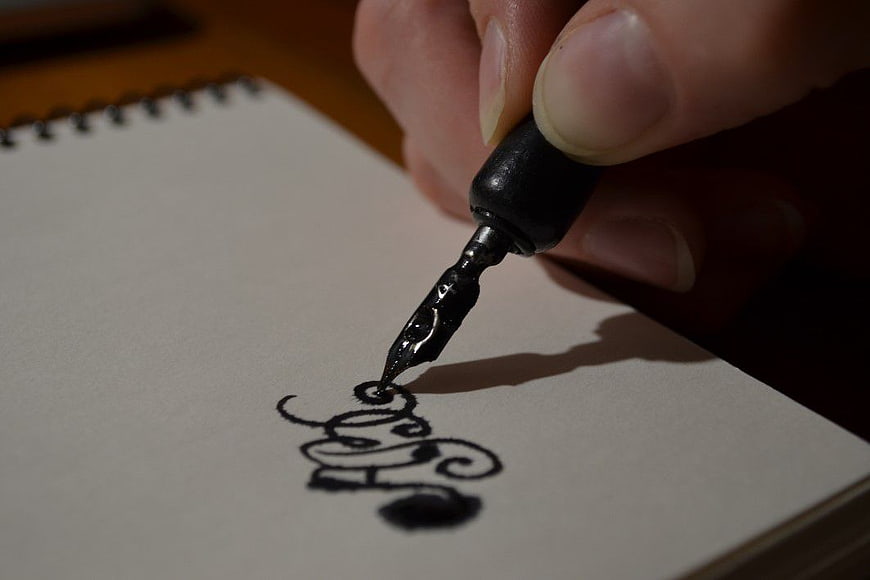 Close-up of hand writing calligraphy with fountain pen