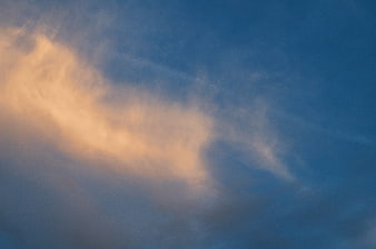 Soft Orange Clouds Against Blue Sky Background