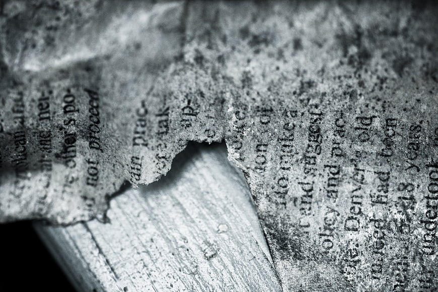 Close-up of torn vintage newspaper on weathered wood