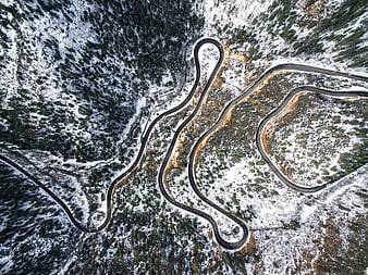 Aerial view of winding mountain road in winter snow