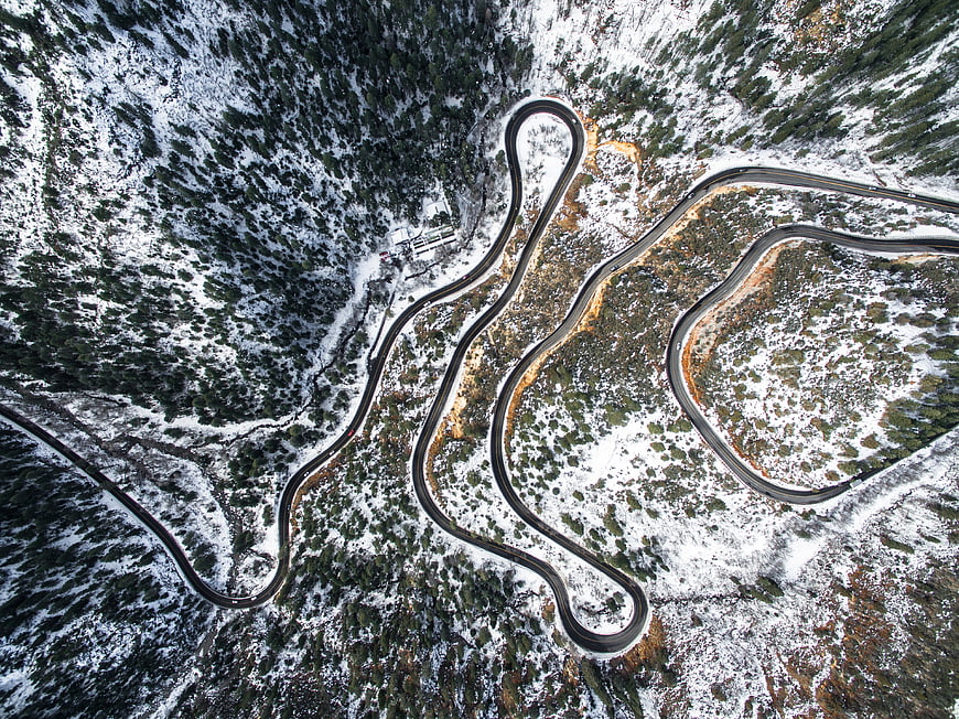 Aerial view of winding mountain road in winter snow