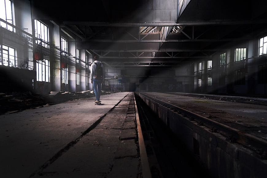 Man Skateboarding in Abandoned Industrial Warehouse