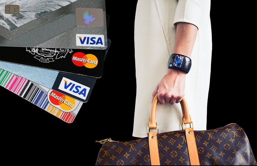 Woman holding luxury handbag with credit cards