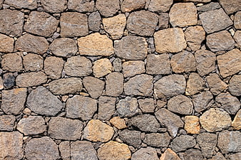 Close-up texture of rough gray and brown cobblestone pavement surface