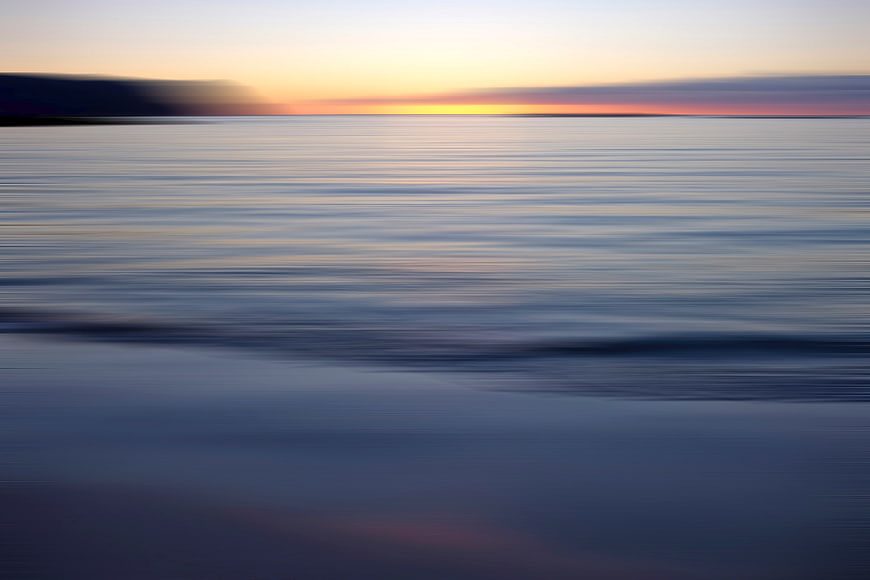 Serene Long Exposure Sunset Over Calm Ocean Water